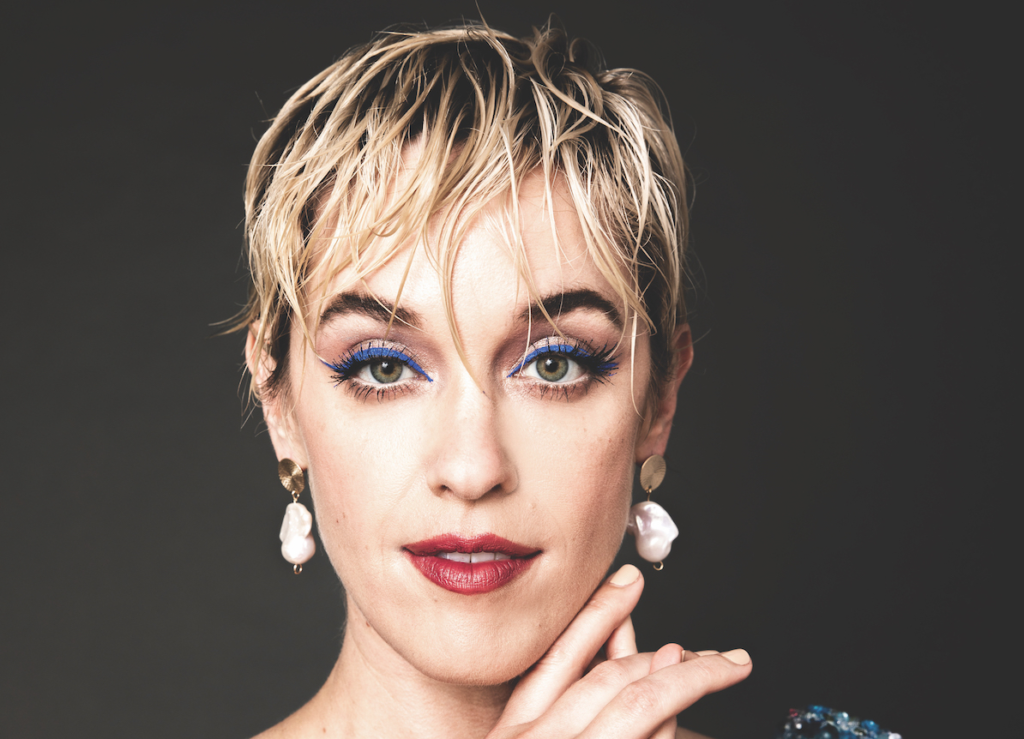 Lauren Morelli wearing bright blue eyeliner, and beautiful pearl earrings, embracing her identity at a photo shoot.