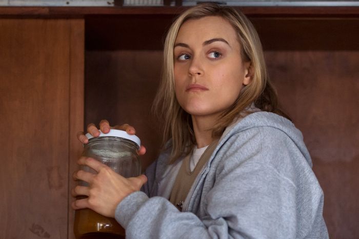 Piper is looking over her shoulder with paranoia, holding a jar in both hands.