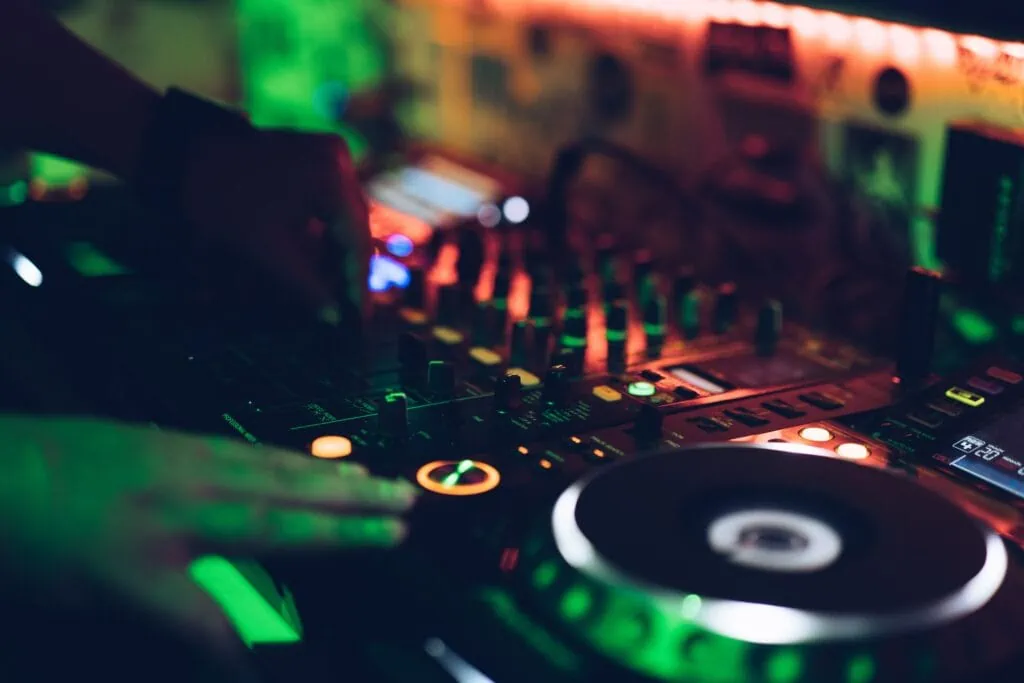 FreeZone is a great spot for lesbian dating because it’s an actual LGBT bar where lesbians gather many times during the week. It welcomes everybody, so expect men, women, and other genders to be there. In this photo, a person is using a DJ mixer at a nightclub.