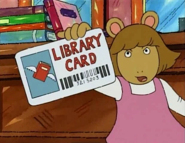 The character DW from the kid’s TV show Arthur shows her library card to the audience.