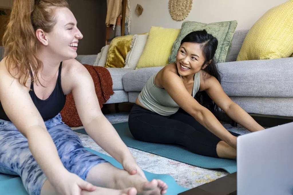 A couple practice yoga together in a living room