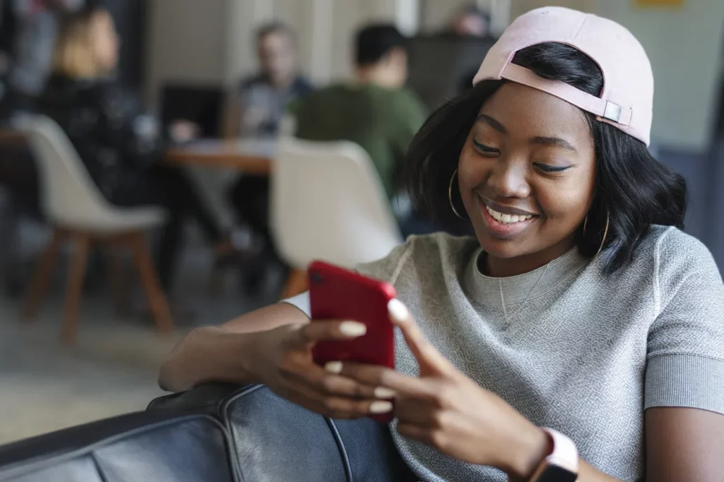 A WLW sits on a couch while scrolling through her phone trying to find a lesbian date for a night out in Shinjuku.