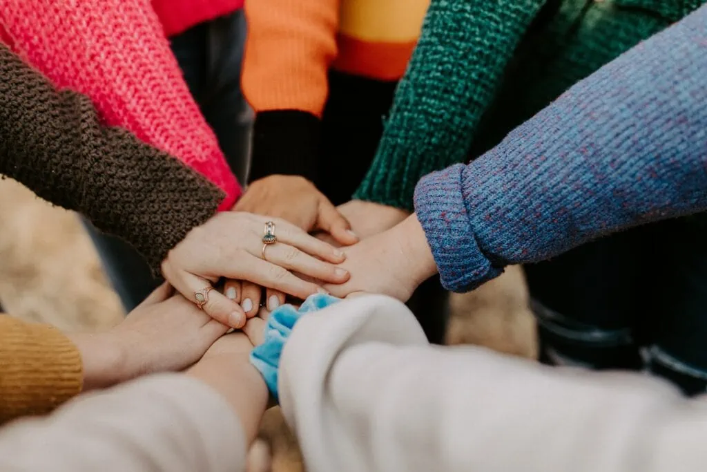 Closeup shot of a group of women stacking their hands together in a huddle.