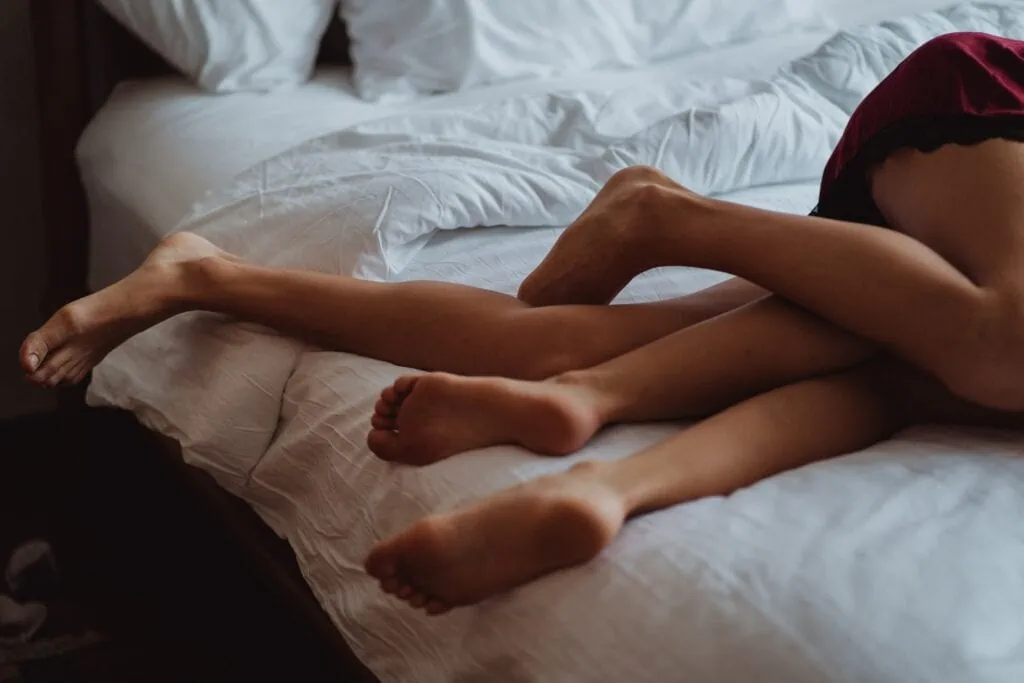  Two lesbians in London in bed together, intertwined 
