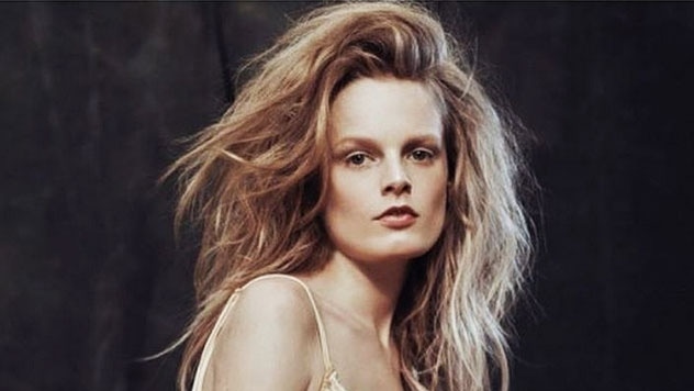 Une image de Hanne Gaby Odiele, mannequin intersexe. Ses cheveux sont longs, blonds et volumineux. Elle porte un soutien-gorge devant un fond noir.