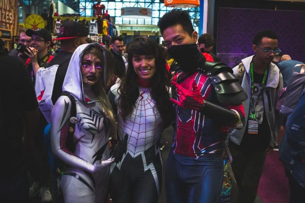 Three people in cosplay pose for the camera at an anime convention. Cosplaying is a great nerdy date idea.