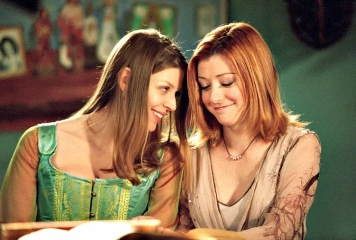 Willow and Tara smiling close to each other, from the TV show “Buffy the Vampire Slayer.”