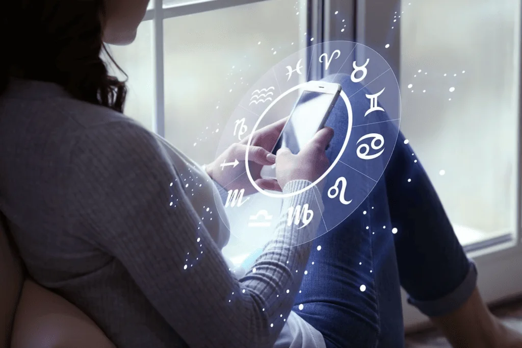 Woman looking at her phone, surrounded by a zodiac sign wheel