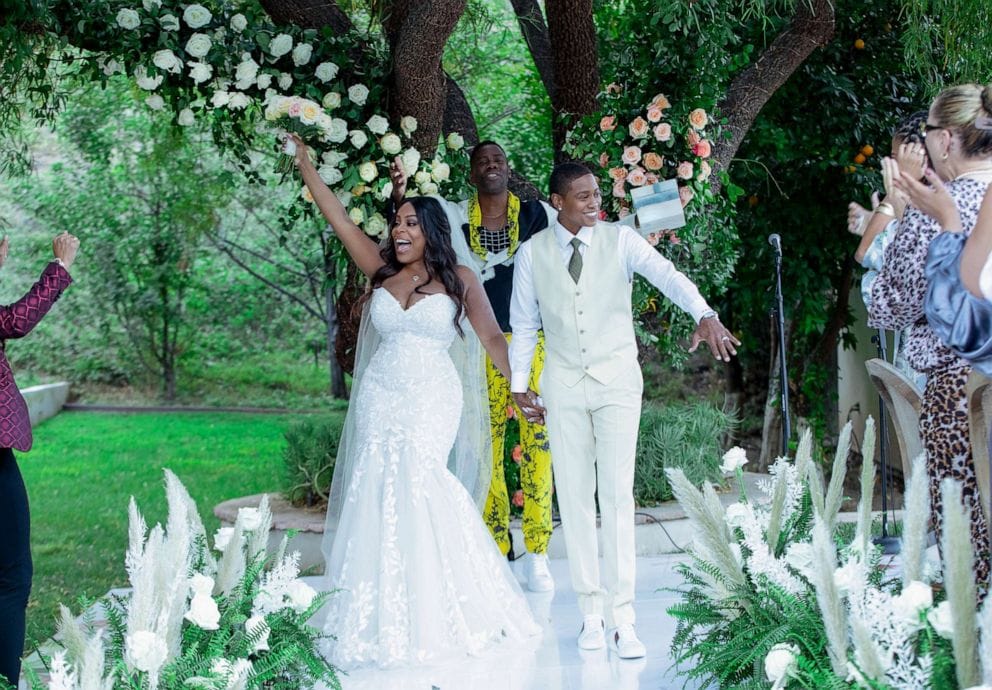 Niecy Nash wears a white wedding dress and stud lesbian Jessica Betts wears a white wedding suit at their 2020 wedding. 