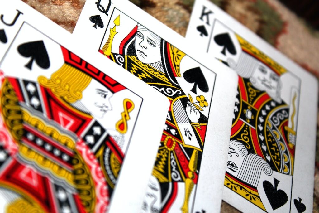 Up-close image of three cards from a regular deck of cards. Classic card games are good ways to increase fun in a relationship. 
