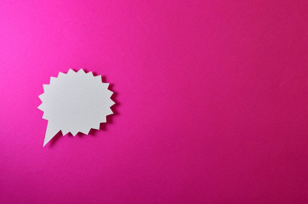 White speech balloon superimposed on a fuschia-colored background, representing the act of talking with women.