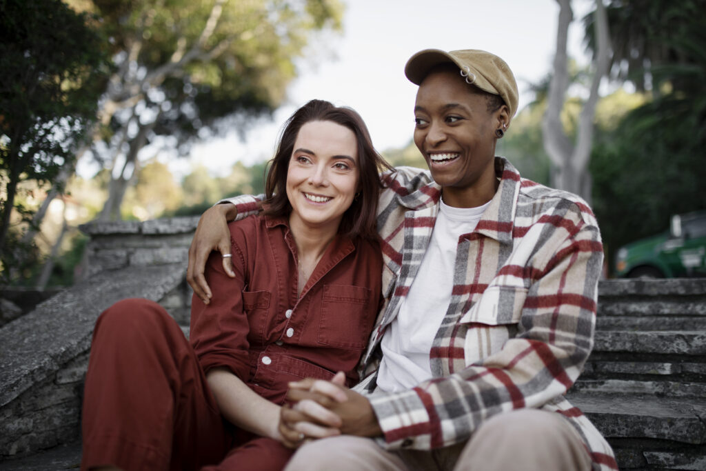 Couple holding each other and sitting on stairs at the park