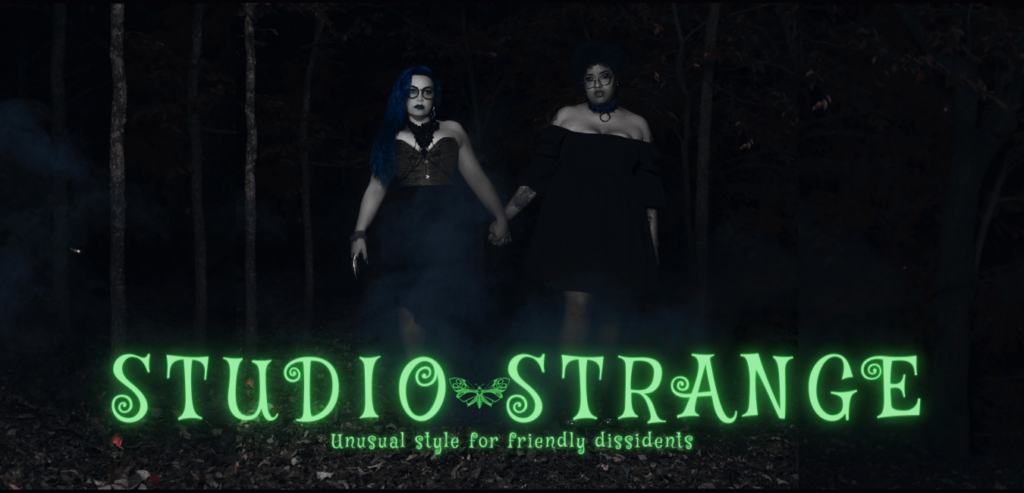 Two queer women, united in solidarity and affection, clasp hands amidst the enigmatic shadows of a dark forest. This powerful image symbolizes Studio Strange's commitment to embracing and celebrating all genders, highlighting their dedication to fostering a welcoming, inclusive environment. Their unique approach to style and beauty is as diverse and unconventional as the mysterious woodland that surrounds them.