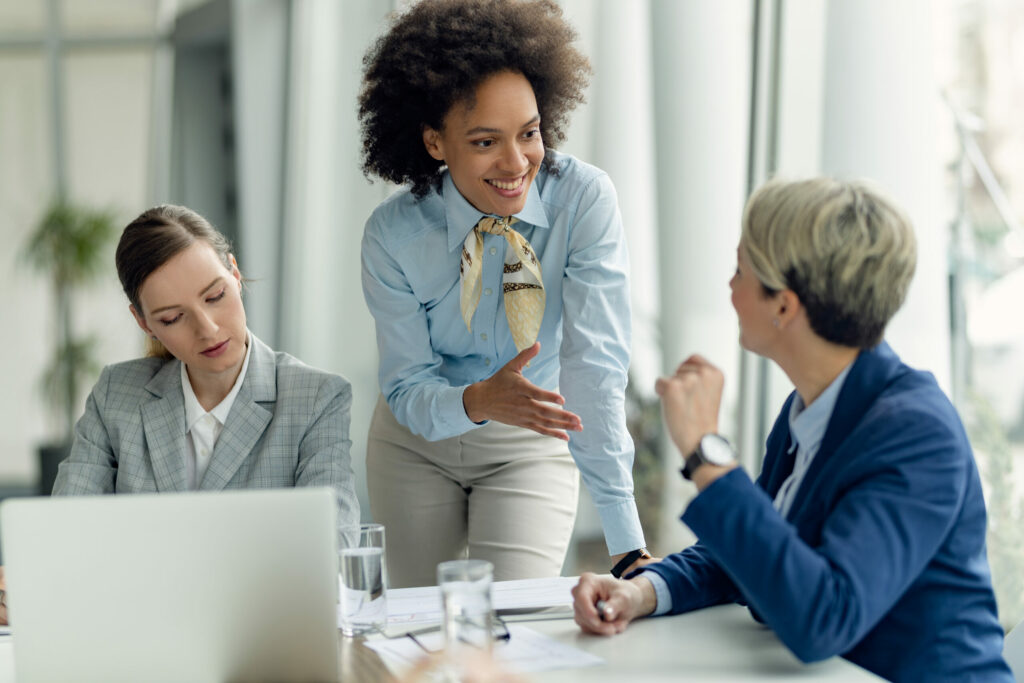 Businesswoman talking to female colleagues while working in the office.
