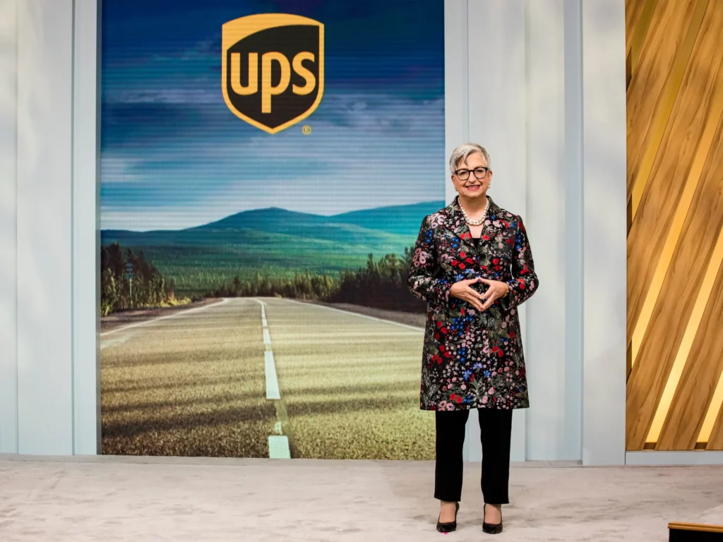 Carol Tomé standing in front of a UPS wall.