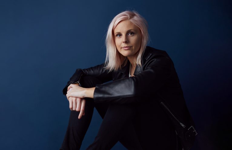 Robyn Exton sitting on the floor and looking at the camera.