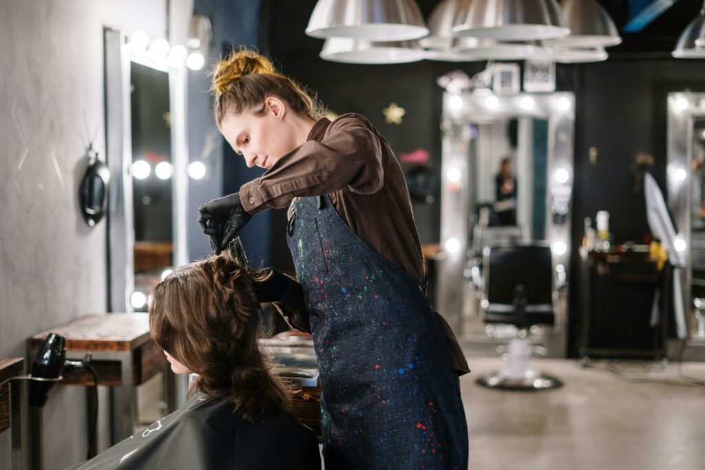 A stylist cutting the hair of a queer woman in a Las Vegas inclusive and LGBT friendly salon
