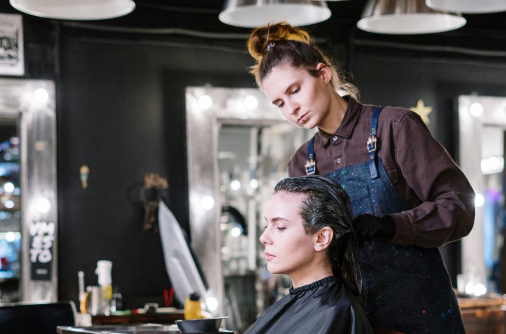 A queer hair stylist creates a fabulous haircut for a lesbian client at an inclusive and LGBTQIA+ friendly salon in Las Vegas