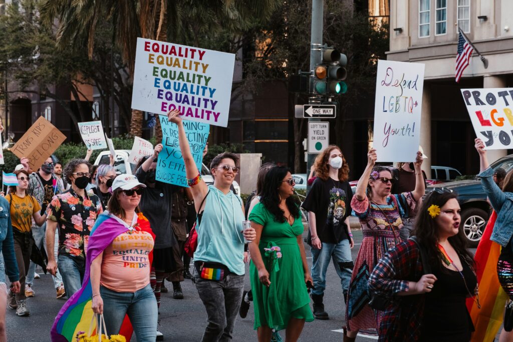 Group of LGBTQIA+ individuals holding a 'Equality' sign at a Pride event in Seattle, representing inclusivity and community support