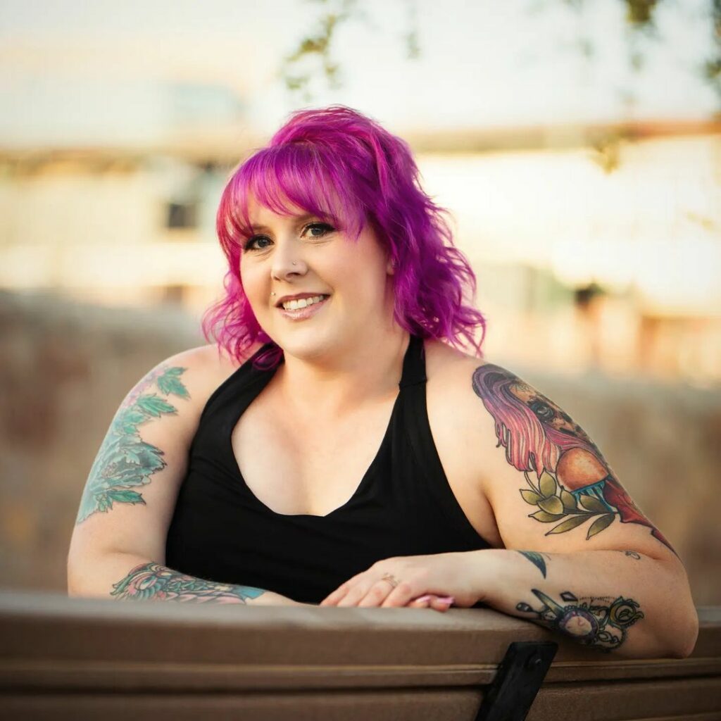 Jess, owner of Hair with Flair salon in El Paso, radiates warmth and joy as she sits on a bench, smiling confidently