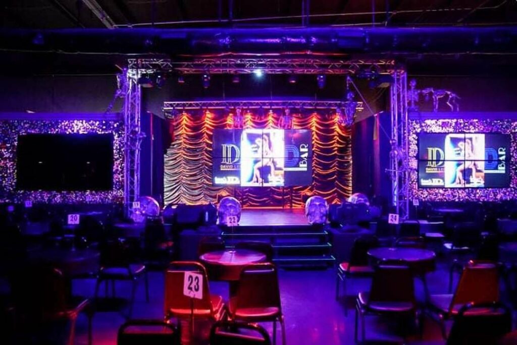 Vibrant nightlife at Touch Bar El Paso, a premier LGBTQIA+ friendly nightclub with spotlights and purple hues