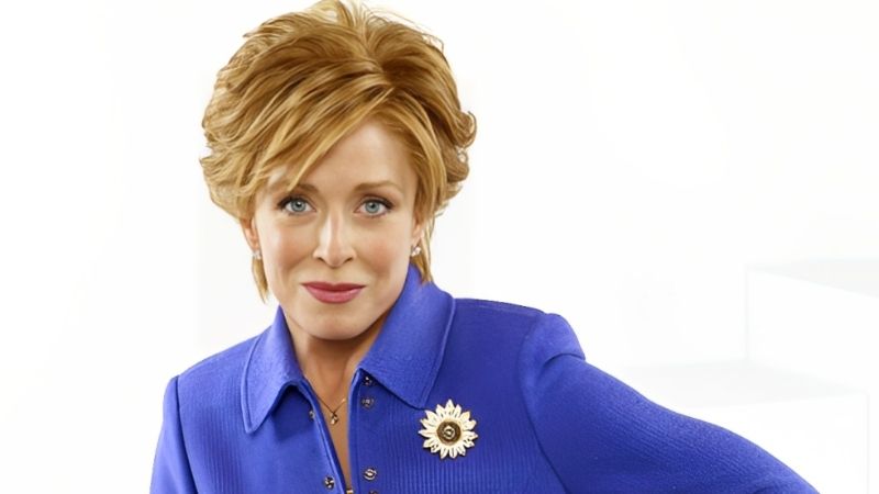 Close-up portrait of Holland Taylor, an older actress with short blonde hair, posing confidently against a white background.