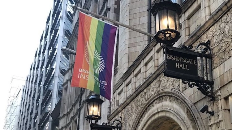 A close-up photo of the entrance to Bishopsgate Institute LGBTQ+ Archives, featuring a pride flag with the institute's name prominently displayed.