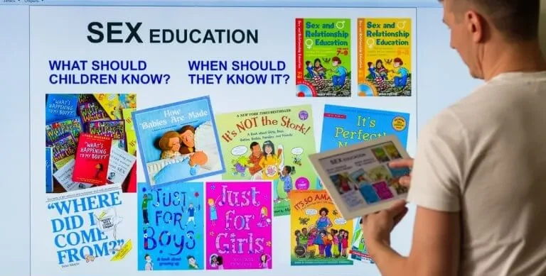 Teacher using interactive board to discuss Fresh guidelines for RSE in UK schools, covering topics like LGBTI, sexual predators, mental health, and challenges of today's social media generation.