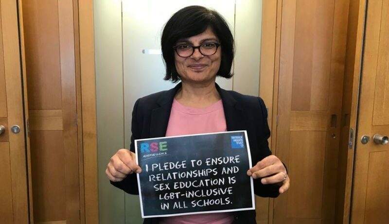 Image of a woman holding a sign advocating for LGBT-inclusive Relationship and Sex Education (RSE) in schools, promoting inclusivity and equality.