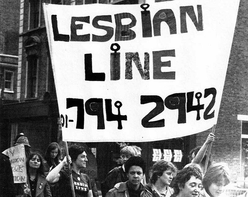 1978 Gay Pride group marching through Shepherds, holding a sign that reads 'Lesbian Line 017942942'