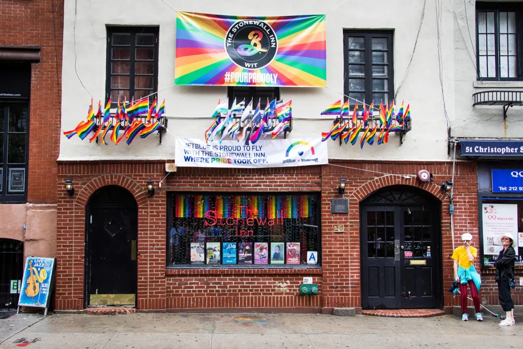 Exterior of Stonewall Inn adorned with colorful Pride flags, celebrating LGBTQ+ pride and history.