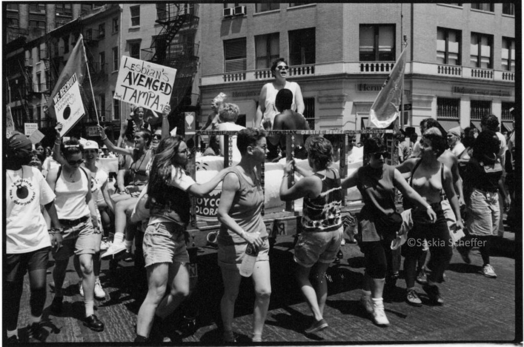 Participants in the first NYC Dyke March pull a huge bed on wheels with lesbians on top as a float, June 26, 1993. Photo by and courtesy of Saskia Scheffer.