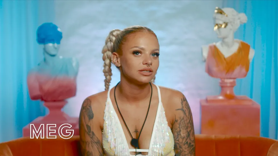 Meg, 24 (She/Her), a character from BBC's I Kissed a Girl TV show, is depicted wearing a white dress with a nose piercing. She is from Goole, West Yorkshire, and works as a fire breather.