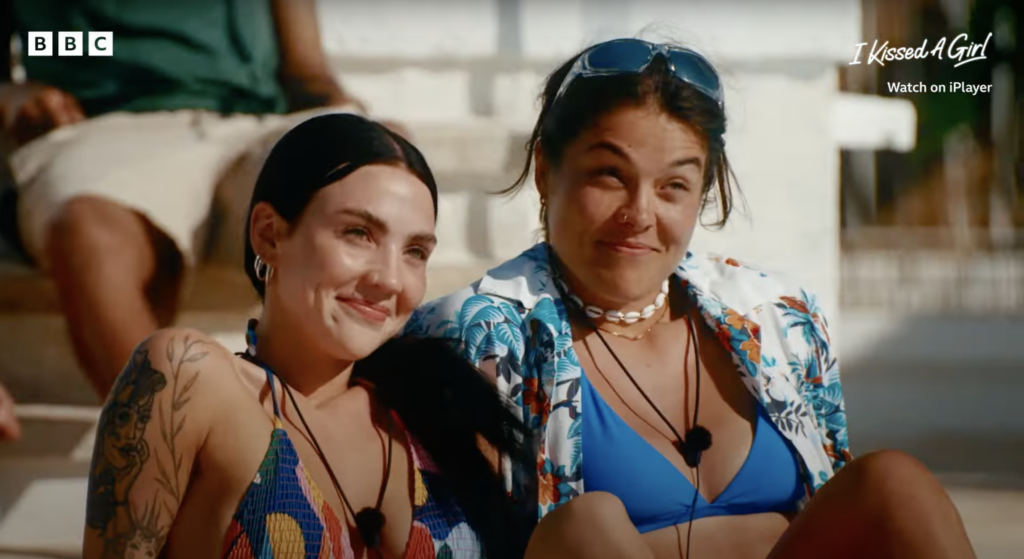 Two actors from BBC's I Kissed a Girl TV show sit by the villa's swimming pool, smiling and exchanging curious glances.