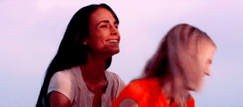 Jordana Brewster, dressed in her D.E.B.S. uniform, embraces another character warmly, conveying a strong sense of camaraderie and emotional connection.