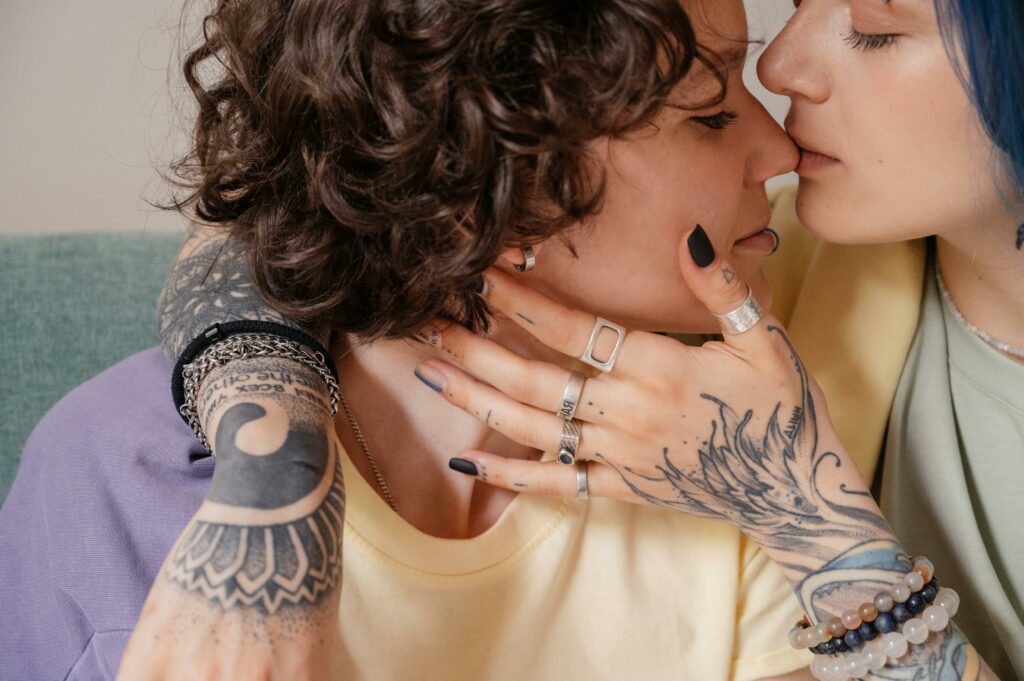 Close-up shot of a couple embracing, one of them wearing black nail polish and many rings including a thumb ring.